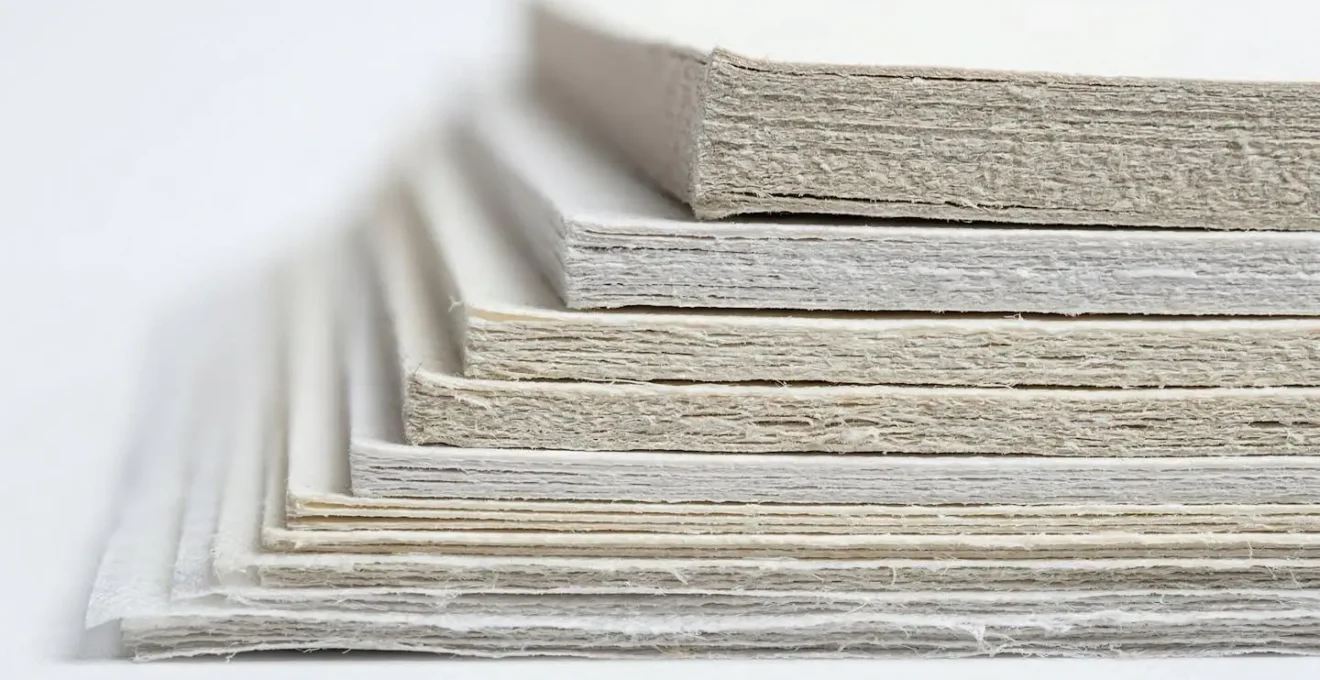Vue macro comparative de l'épaisseur de différents papiers de flyers montrant les textures