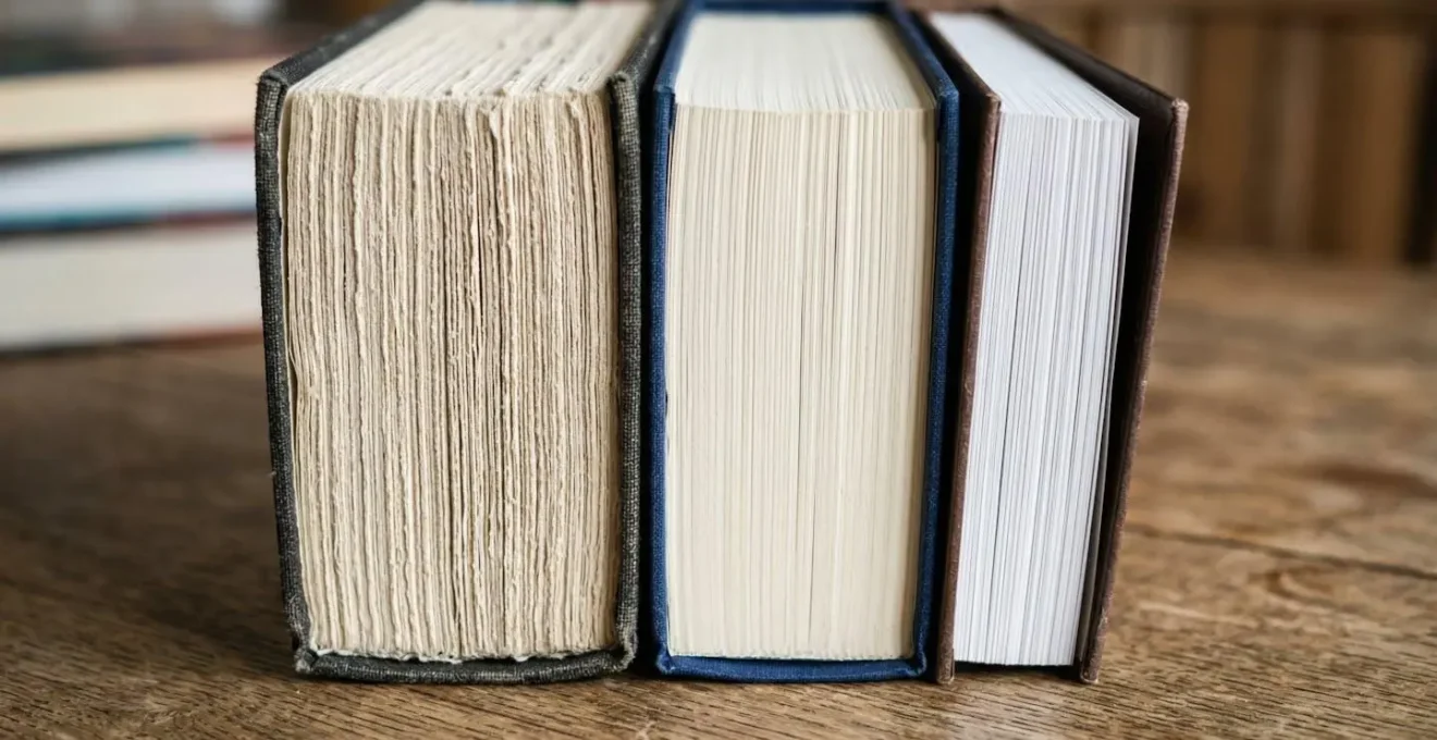 Vue macro de trois tranches de livres côte à côte montrant des épaisseurs et textures de papier différentes